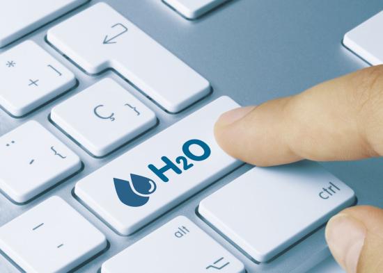 A finger over a keyboard, reaching for a key labeled H2O with a water symbol